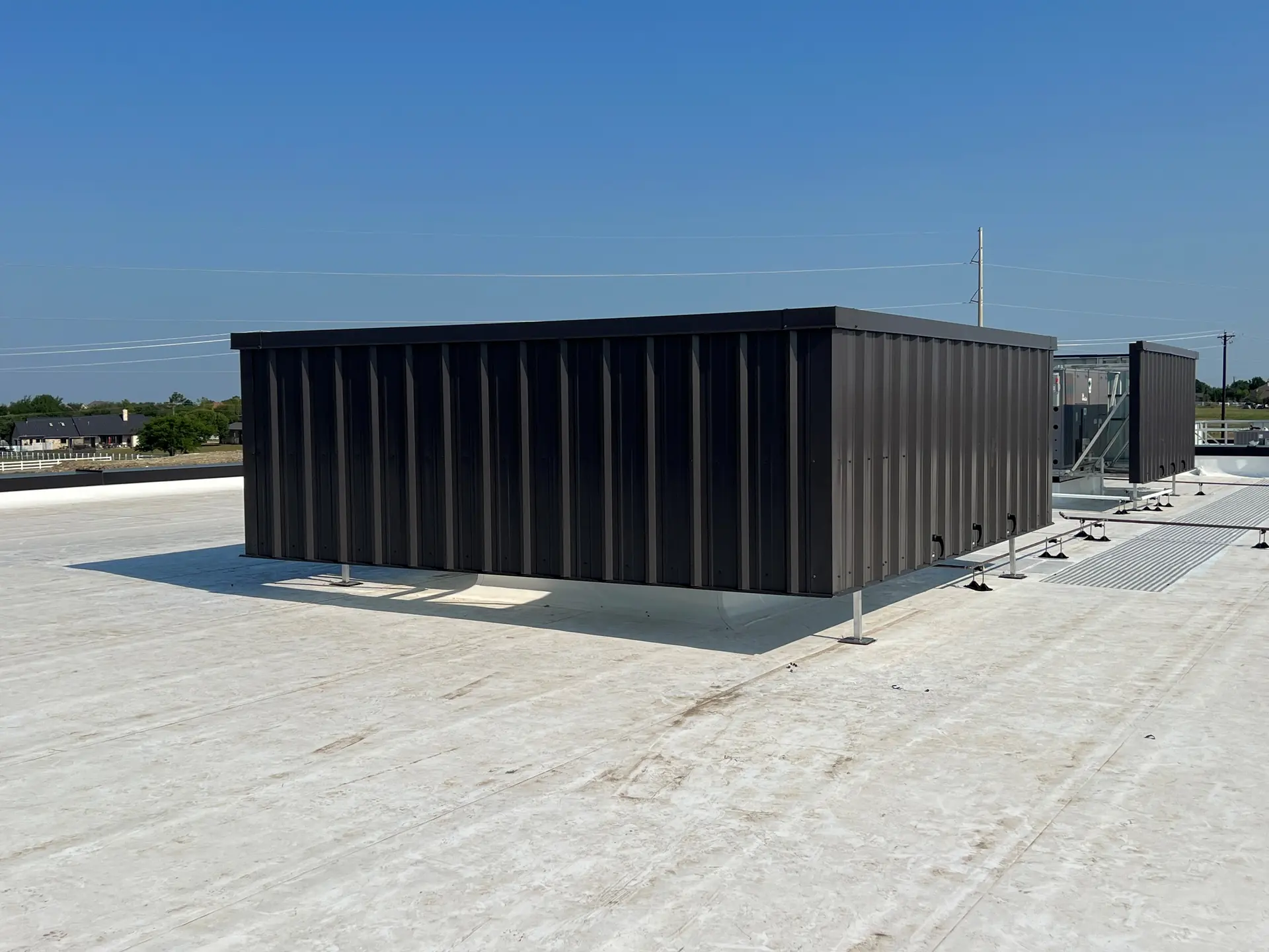 Commercial roof with a steel screen wall hiding packaged HVAC units