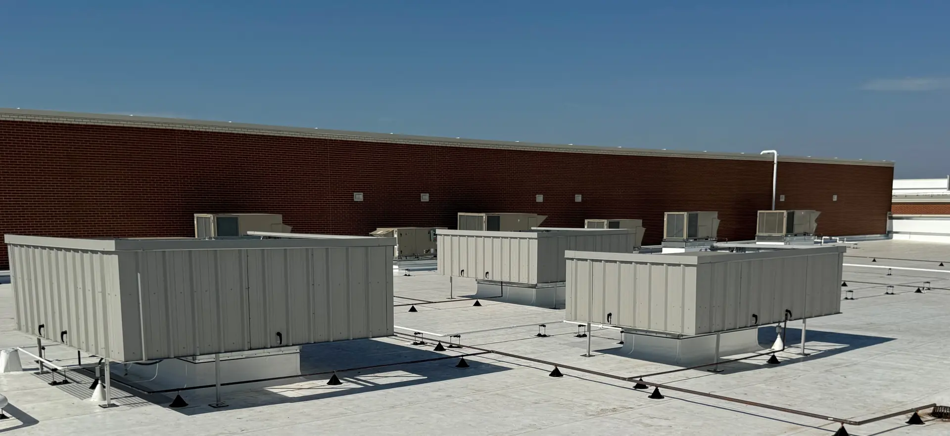 Steel screen wall on a commercial roof concealing packaged HVAC equipment from street view